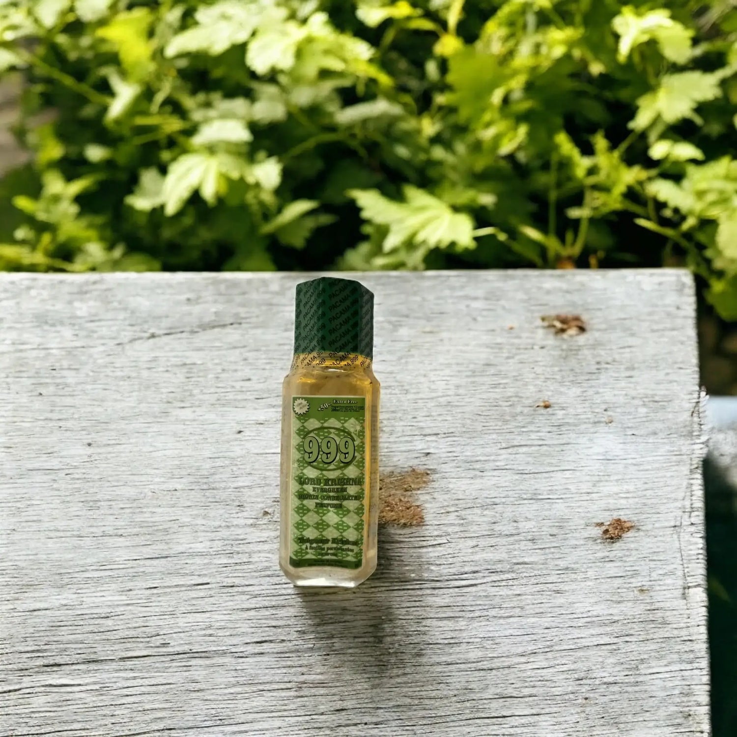 Une bouteille de parfum 999 posée sur une table de jardin