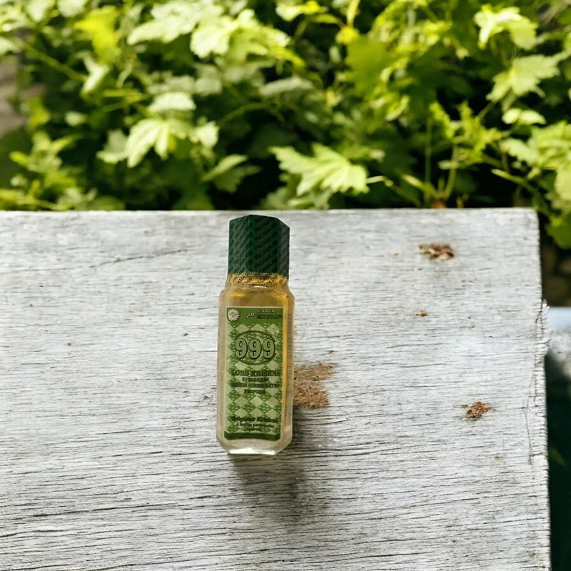 Une bouteille de parfum 999 posée sur une table de jardin