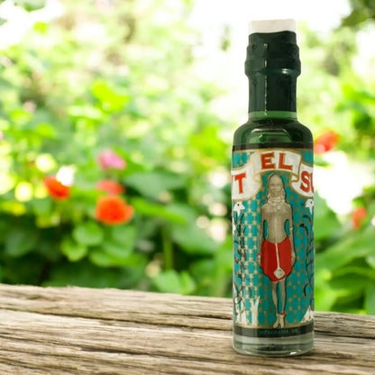 Une bouteille de parfum Bint el Sudan posée sur une table dans un jardin