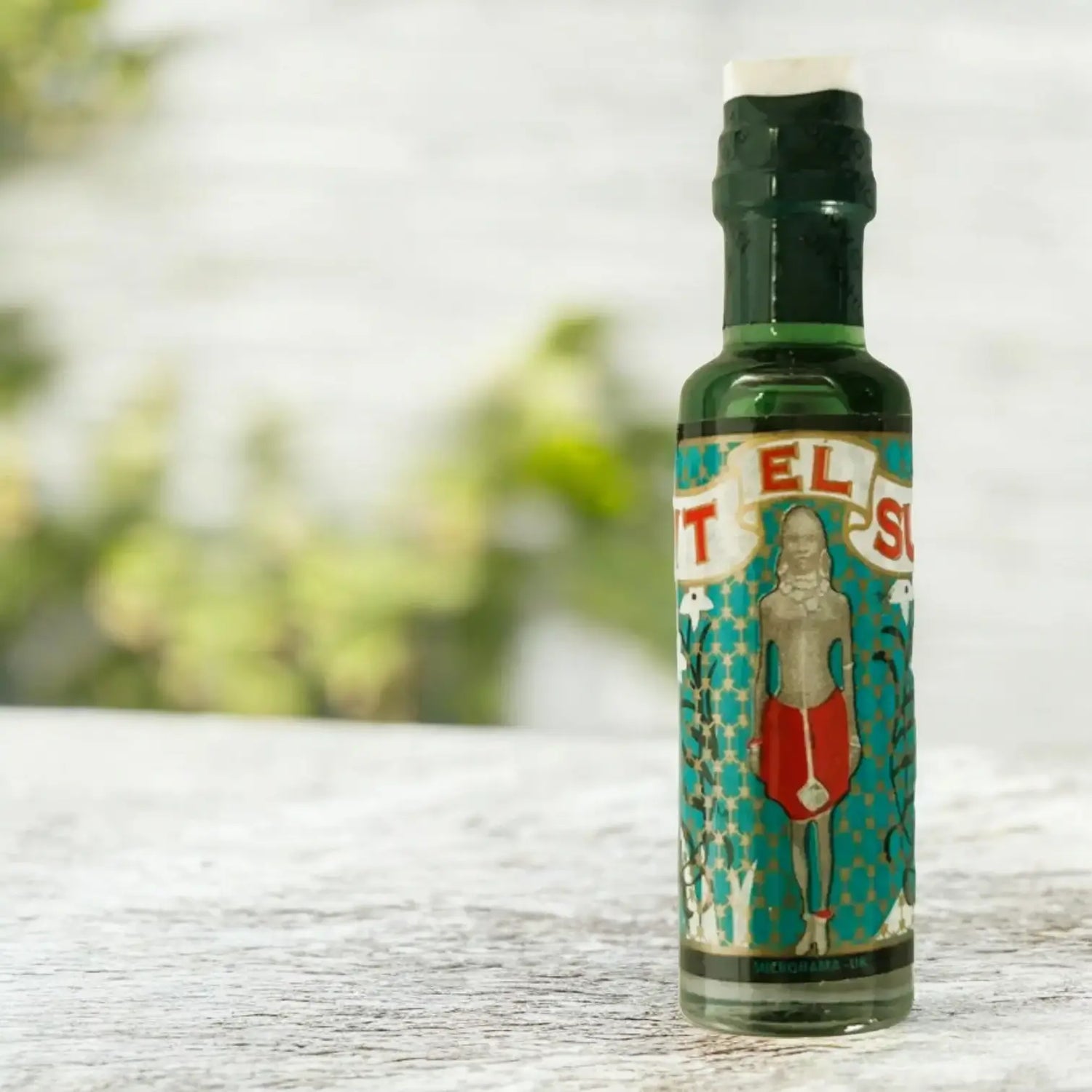 Une bouteille de parfum Bint el Sudan posée sur une table grise