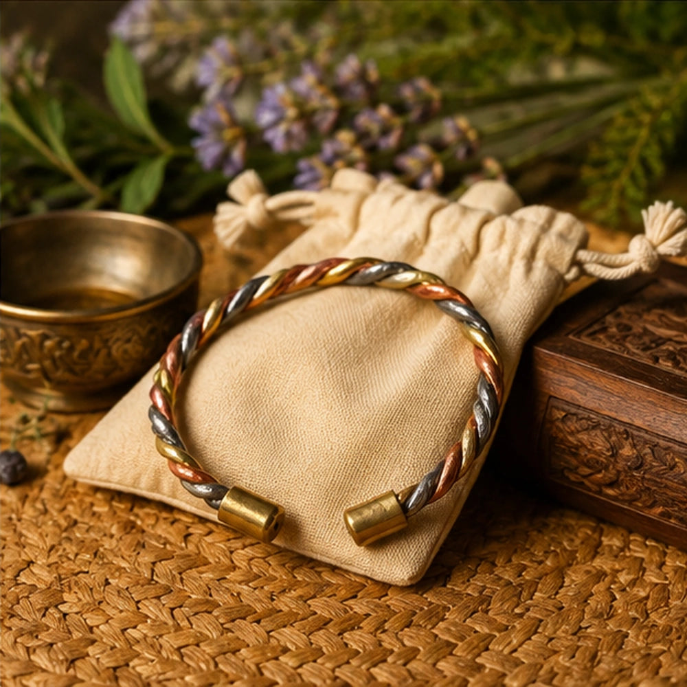 Bracelet de protection trois métaux présenté sur une pochette en tissu dans un décor rituel premium.