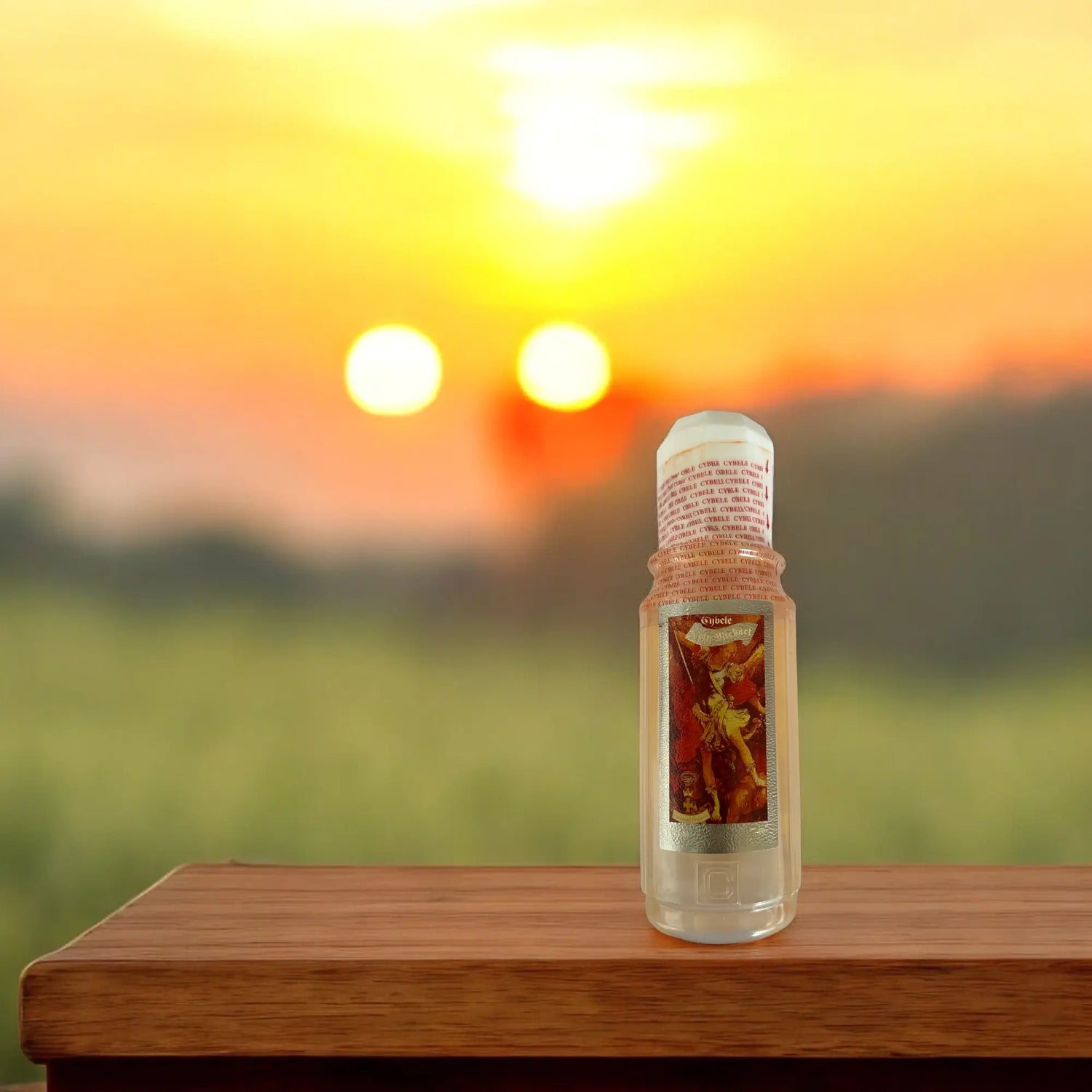 Bouteille du parfum saint Michel posé sur une table en bois avec un couché de soleil en arrière plan