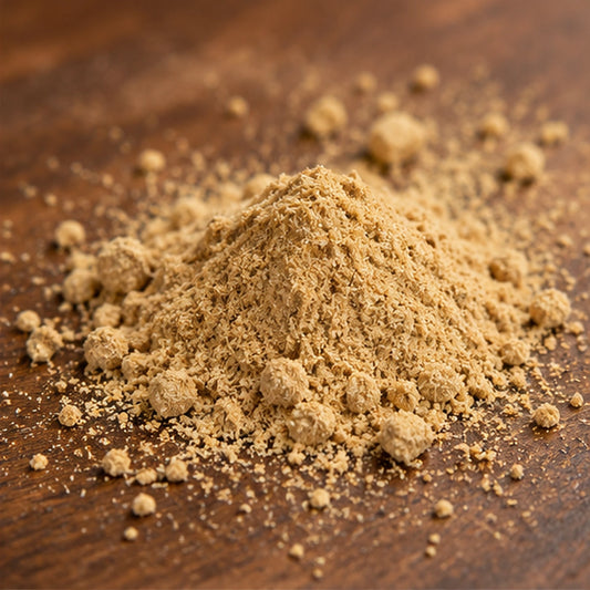 Petit tas de poudre spirituelle Prospérité beige clair sur une table en bois, avec grains et petits amas visibles.