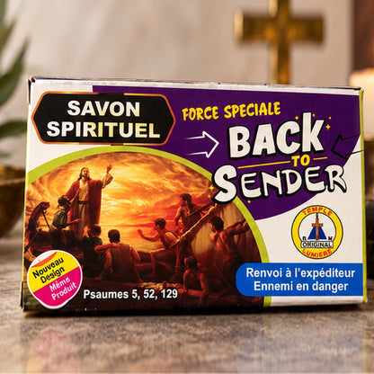 Savon d’Exorcisme Back to Sender en boîte violette, présenté dans une ambiance rituelle chaleureuse et lumineuse.